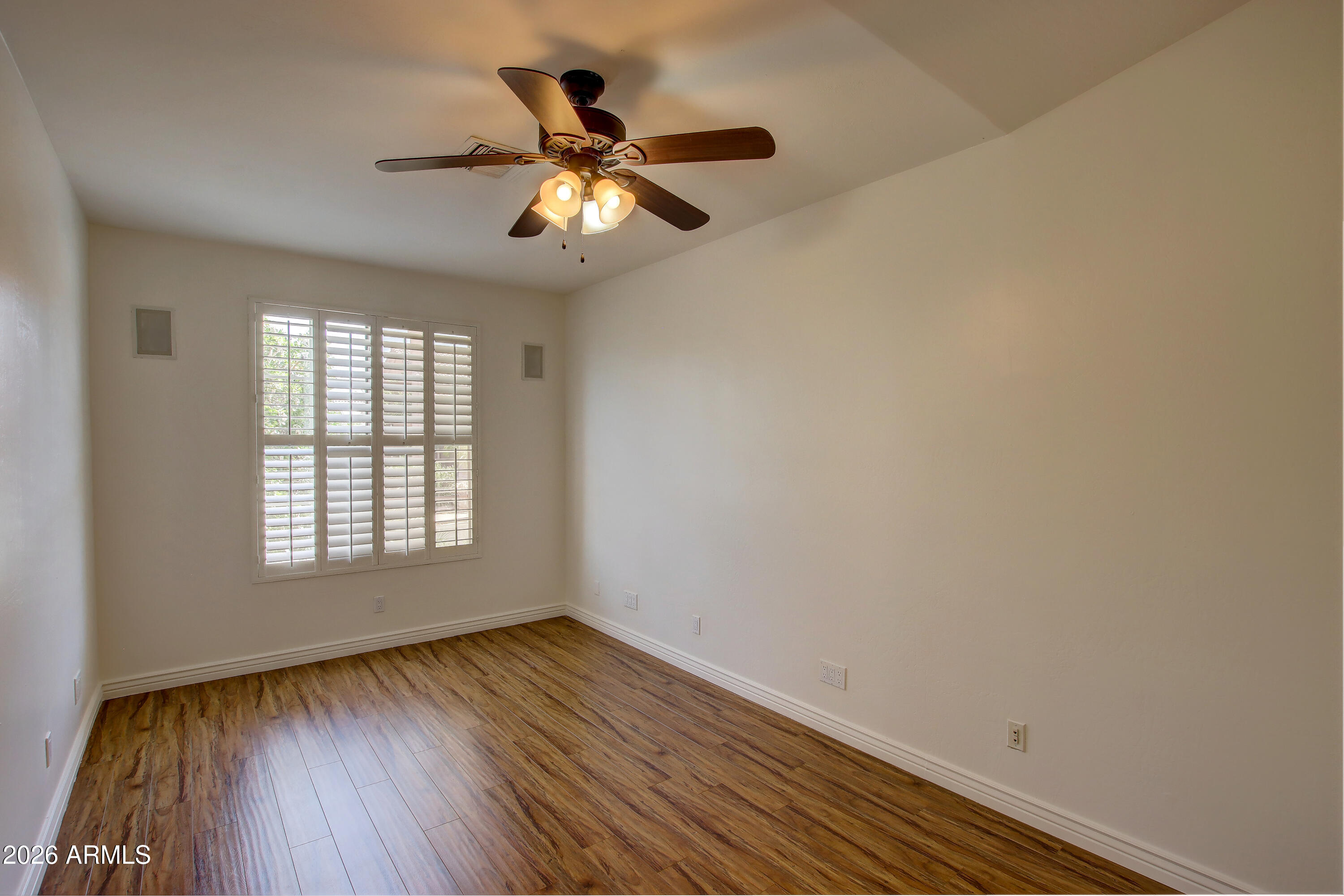 1918 East Marilyn Road Phoenix, AZ 85022 - Photo 10 of 43 a view of an empty room with wooden floor and a window