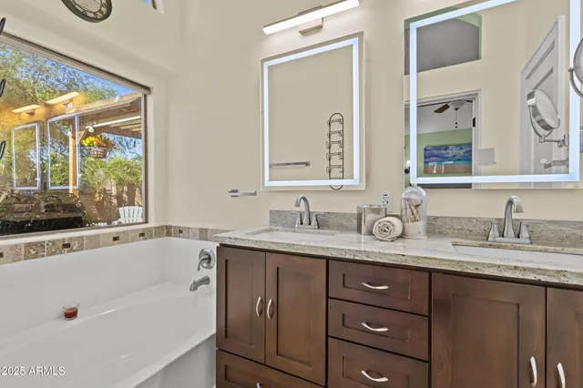 a bathroom with a tub sink and mirror