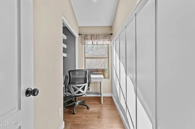 a view of a workspace with furniture and a window