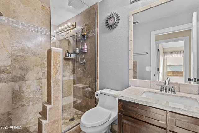 a bathroom with a granite countertop sink toilet and shower