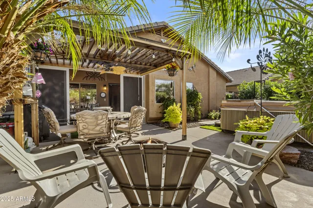 a view of a patio with table and chairs under an umbrella with a barbeque
