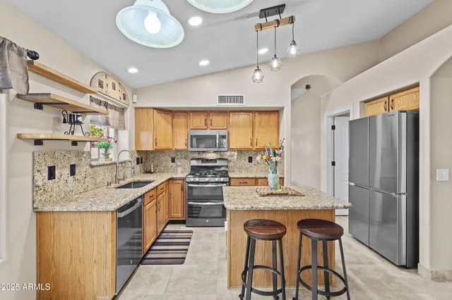 a kitchen with stainless steel appliances granite countertop a sink stove and refrigerator