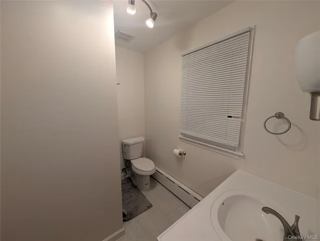 a bathroom with a granite countertop toilet and a sink