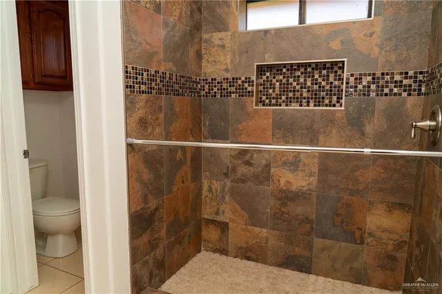 a bathroom with a toilet and a shower