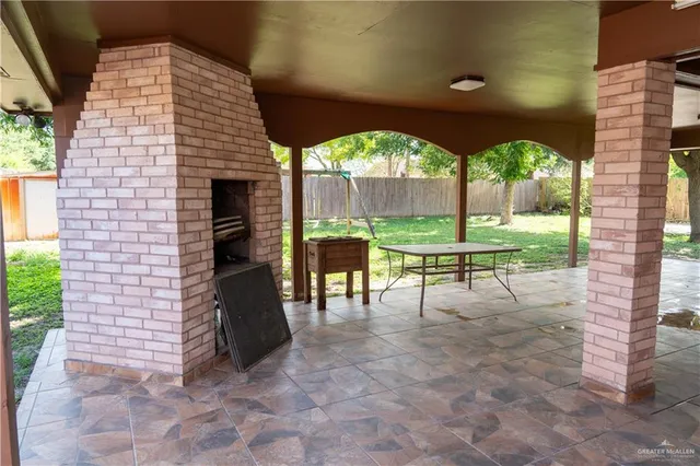 a view of a porch with a table and chairs under an umbrella