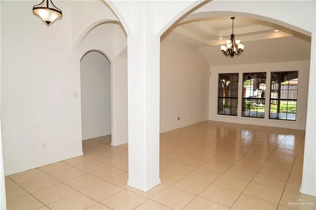 an empty room with windows and chandelier