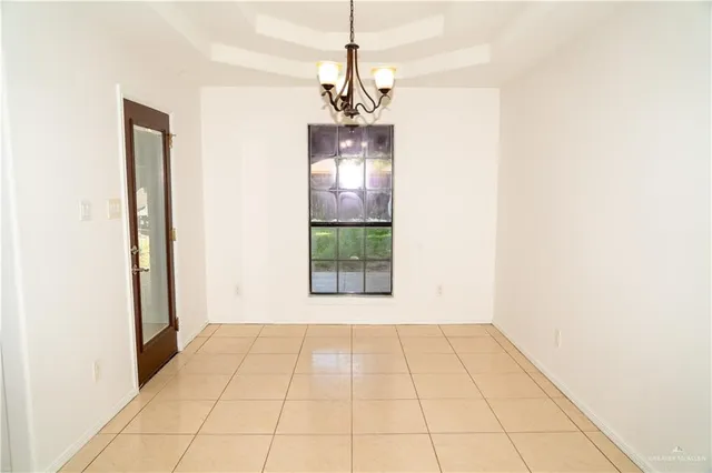 a view of a room with a chandelier and refrigerator
