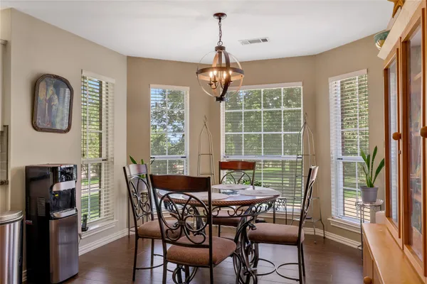 a dining room with furniture window wooden floor and a chandelier