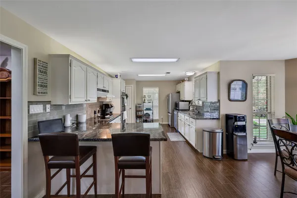 a large kitchen with a table and chairs