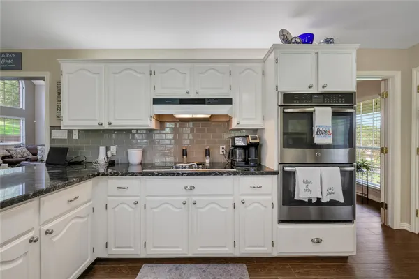 a kitchen with stainless steel appliances granite countertop a stove and cabinets