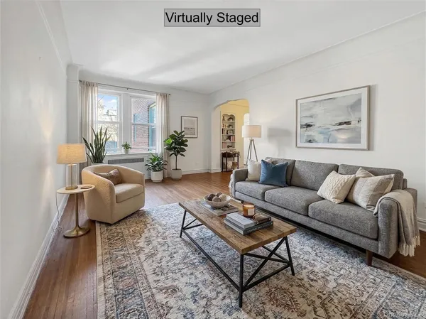 a living room with furniture wooden floor and a large window