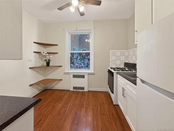 a kitchen with granite countertop a stove top oven a sink a counter space and cabinets