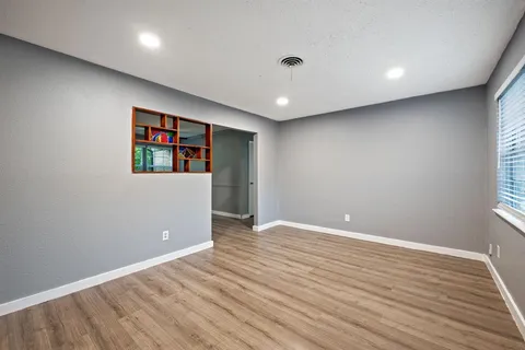 an empty room with wooden floor and painting on the wall