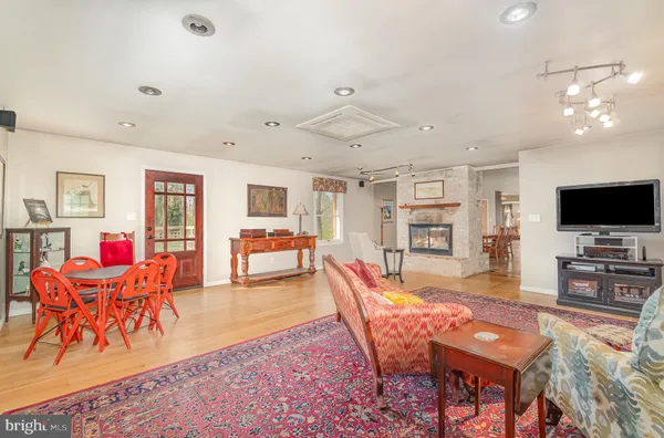 a living room with furniture a chandelier and a dining table
