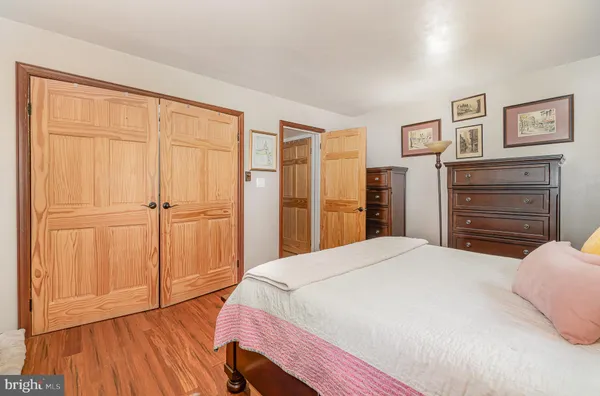 a bedroom with a bed and a large window with wooden floor