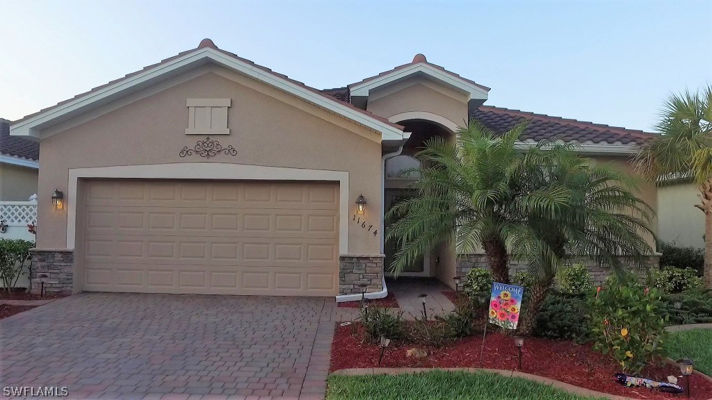 11674 Eros Road Lehigh Acres, FL 33971 - Photo 1 of 35 a front view of a house with a yard