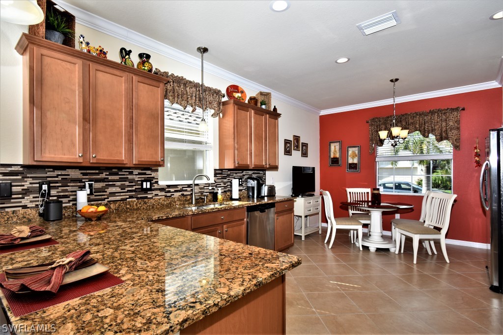 11674 Eros Road Lehigh Acres, FL 33971 - Photo 11 of 35 a large kitchen with lots of counter and chairs