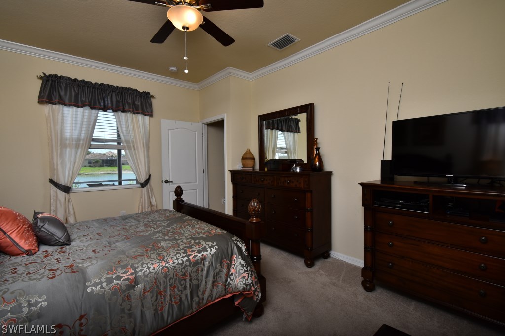 11674 Eros Road Lehigh Acres, FL 33971 - Photo 14 of 35 a bedroom with a bed and a flat tv screen on dresser