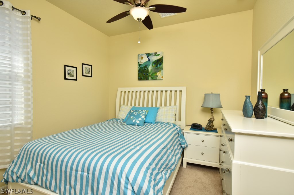 11674 Eros Road Lehigh Acres, FL 33971 - Photo 18 of 35 a bedroom with a bed and a chandelier