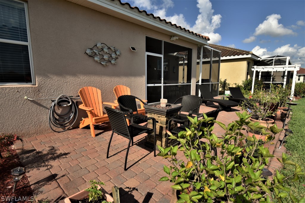 11674 Eros Road Lehigh Acres, FL 33971 - Photo 25 of 35 a view of a chairs and table in a patio