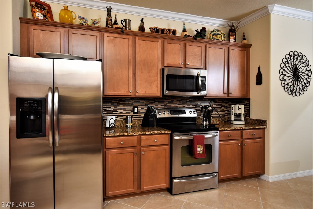 11674 Eros Road Lehigh Acres, FL 33971 - Photo 8 of 35 a kitchen with stainless steel appliances granite countertop a refrigerator stove and microwave
