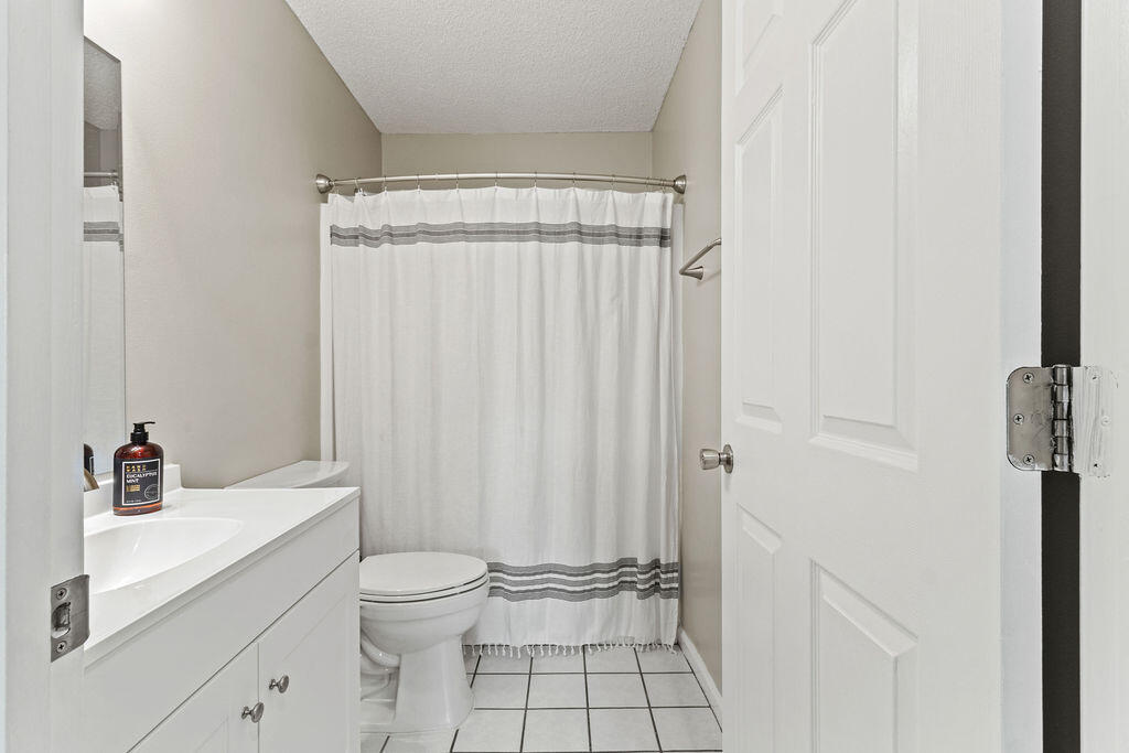 1791 Old Ranch Road Fort Walton Beach, FL 32547 - Photo 23 of 30 a bathroom with a sink a toilet and shower curtain