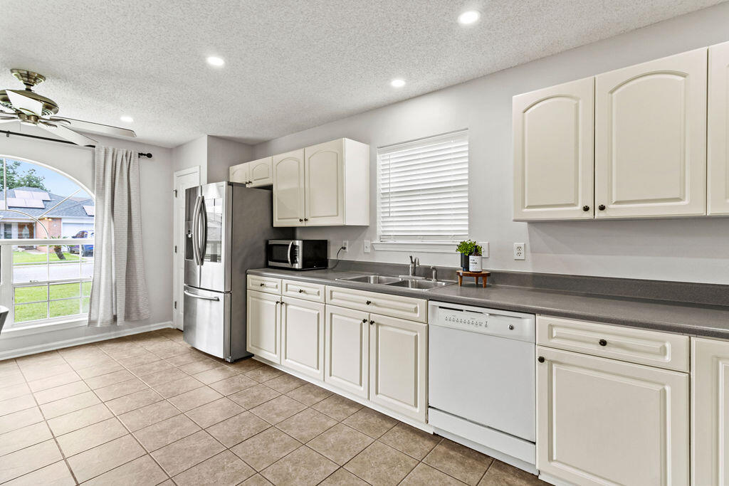 1791 Old Ranch Road Fort Walton Beach, FL 32547 - Photo 9 of 30 a kitchen with stainless steel appliances granite countertop a refrigerator and white cabinets