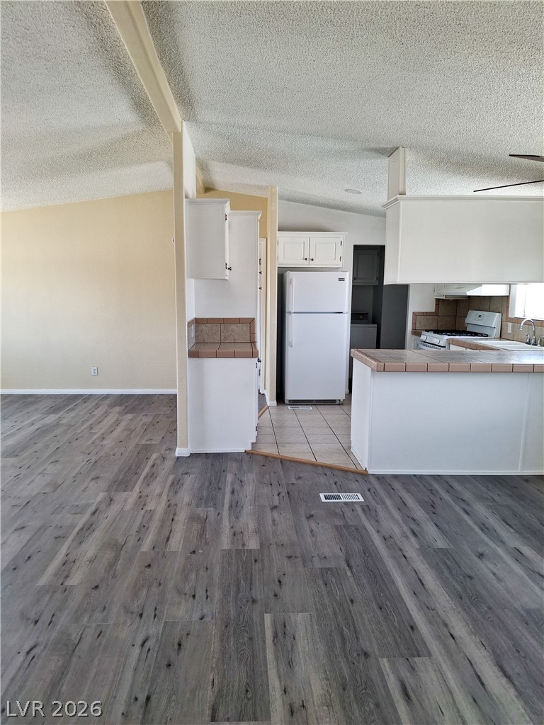 4550 Horn Road Pahrump, NV 89048 - Photo 4 of 12 Functional kitchen with ample cabinet space opens into a spacious living area.