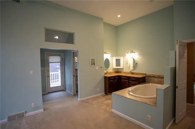 a spacious bathroom with a bathtub a sink a light fixture and a stove