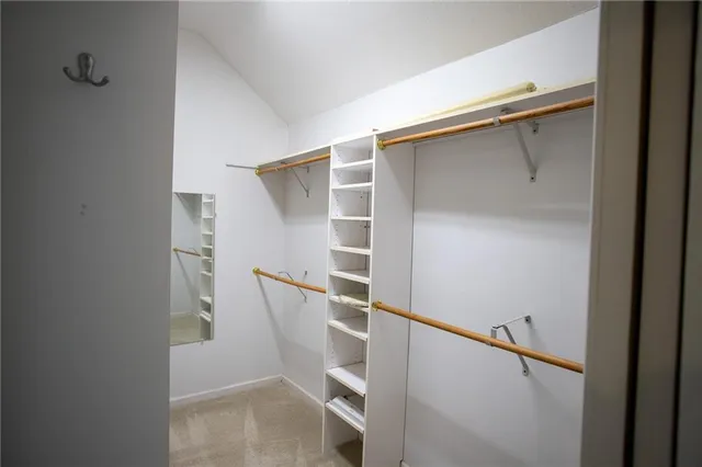 a view of walk in closet with empty racks