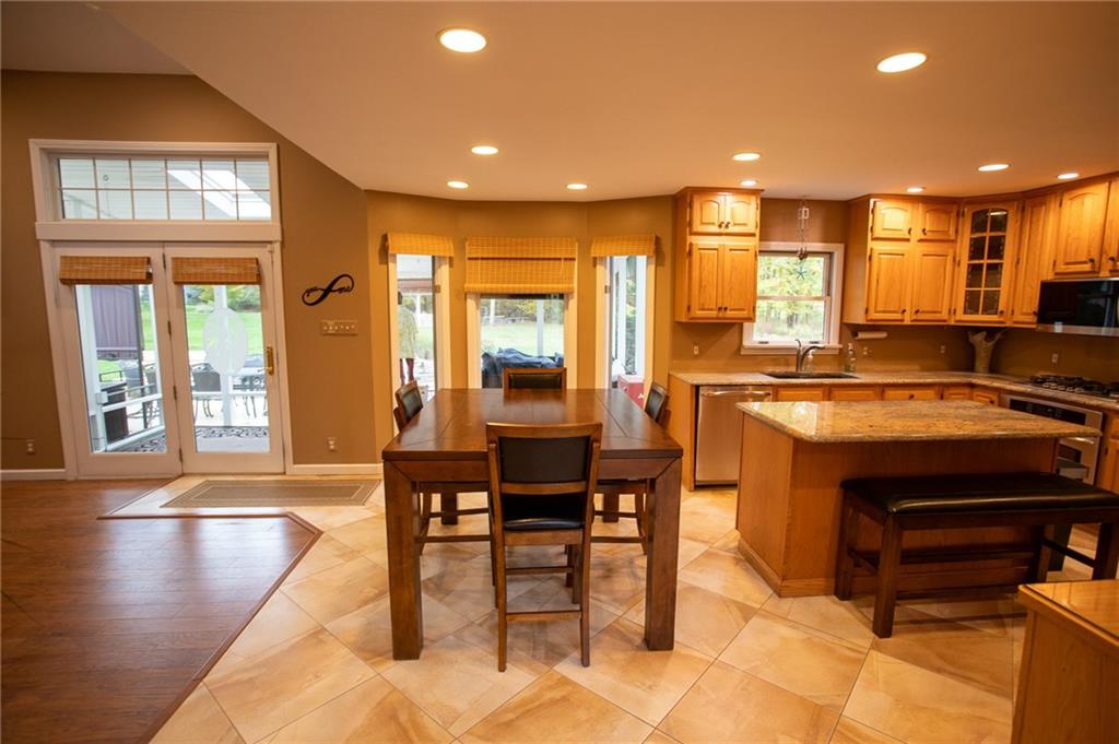 357 Morningstar Lane Neshannock, PA 16105 - Photo 2 of 25 a open kitchen with stainless steel appliances granite countertop a stove a sink a dining table and chairs with wooden floor