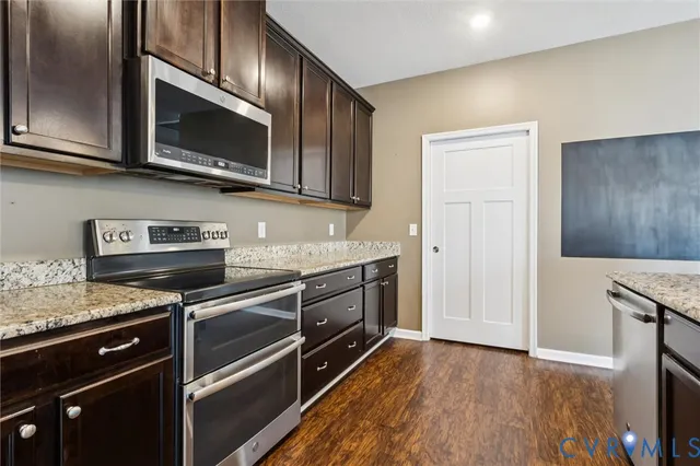 a kitchen with stainless steel appliances granite countertop a stove microwave and sink