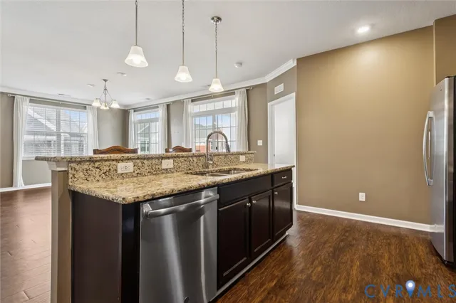 a kitchen with granite countertop a sink and a refrigerator