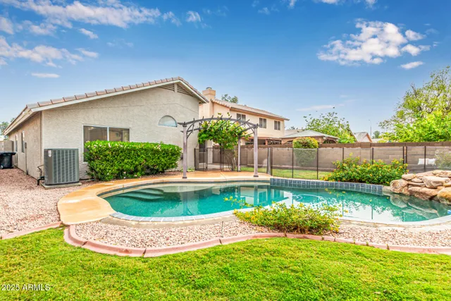 a view of a house with swimming pool and a yard