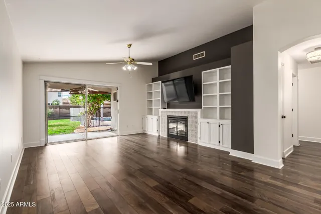 wooden floor fireplace and windows in an empty room