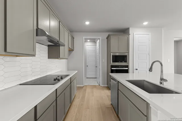 a kitchen with stainless steel appliances kitchen island a sink stove and refrigerator