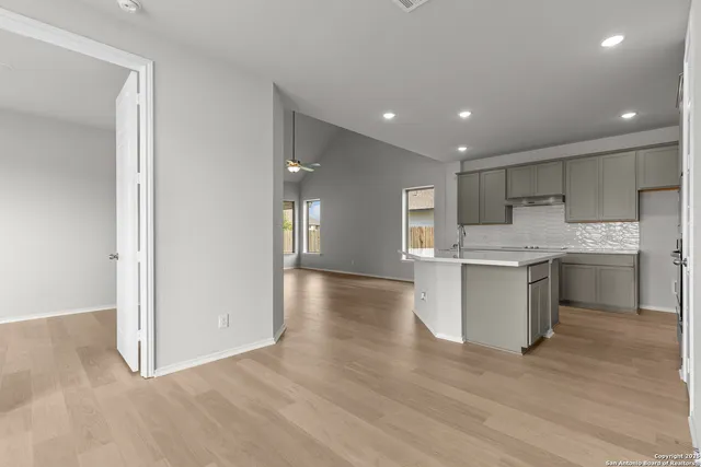 a kitchen with a refrigerator sink and cabinets
