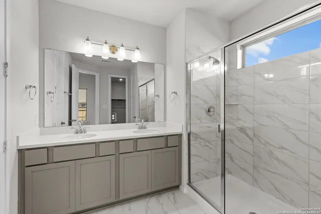 a bathroom with a double vanity sink mirror and shower