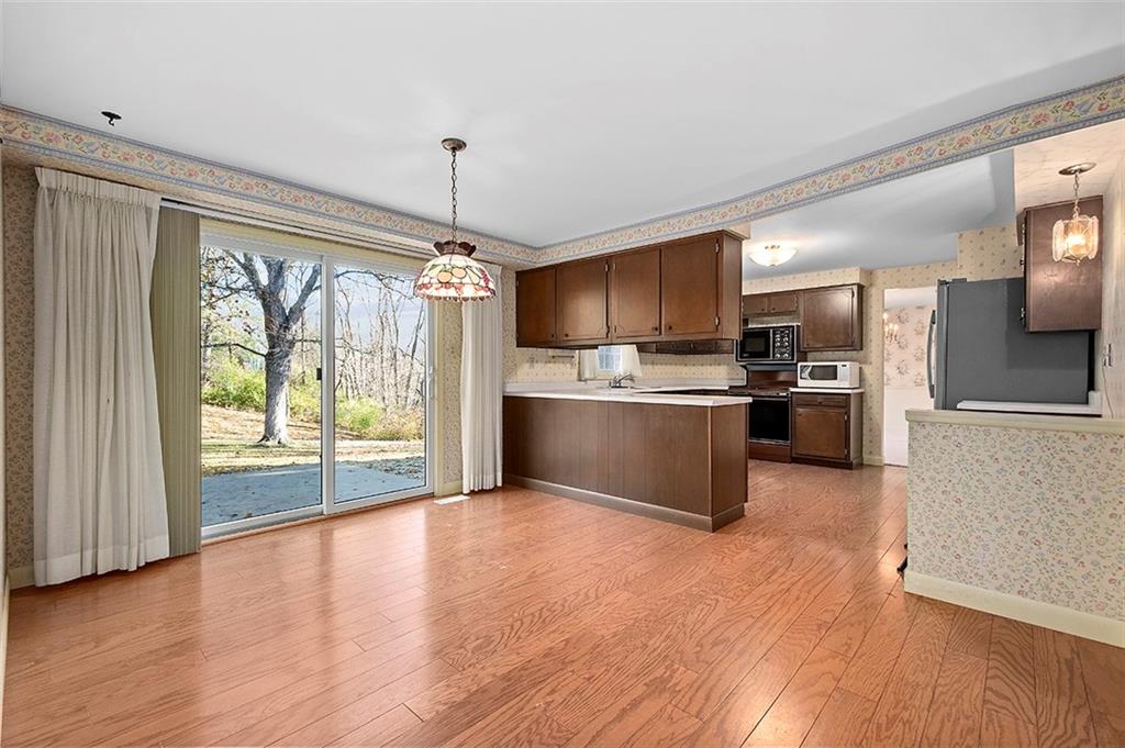 1619 Tiffany Ridge Drive Pittsburgh, PA 15241 - Photo 10 of 25 a kitchen with stainless steel appliances granite countertop a refrigerator a stove top oven a sink with wooden floor and cabinets