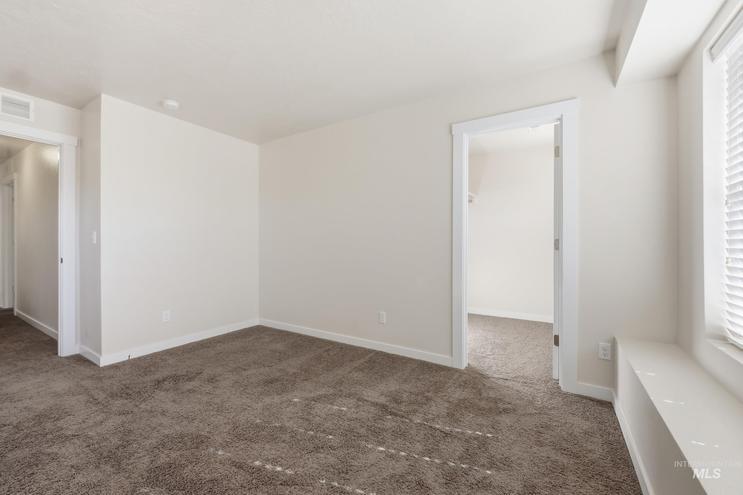 4855 South Chex Way Boise, ID 83709 - Photo 24 of 47 Neutral tone walls with brown carpet flooring