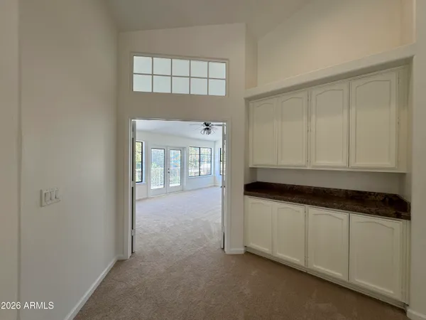 a kitchen with granite countertop white cabinets and sink
