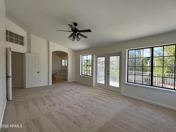a view of an empty room with a window and a kitchen
