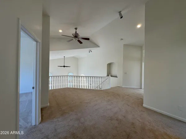 a view of a room with a ceiling fan and window
