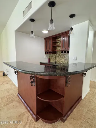 a room with kitchen island a sink and wooden floor