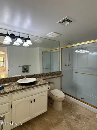 a bathroom with a granite countertop sink mirror and toilet