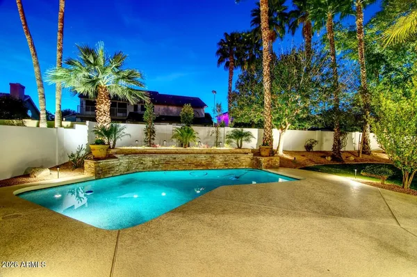 a view of a swimming pool with lawn chairs under an umbrella