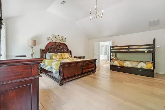 a bed sitting in a spacious bedroom next to a window with a flat screen tv and balcony