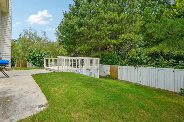 a view of a yard with plants and trees