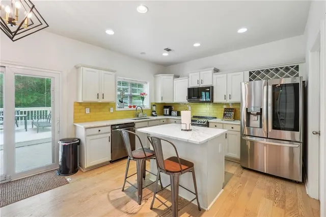 a kitchen with a stove a sink a dining table and chairs