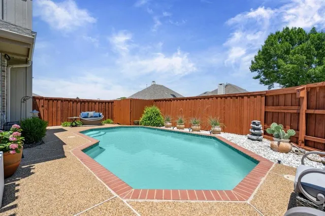a view of a backyard with swimming pool and furniture